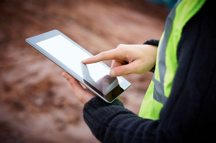 Photo of a technician using an iPad in the field